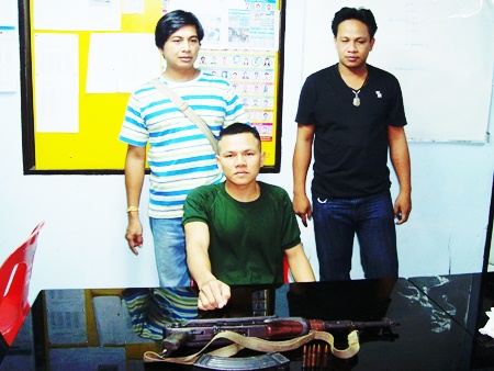 Worawut Langlorm (seated) points to the AK-47 he tried to sell over the Internet.